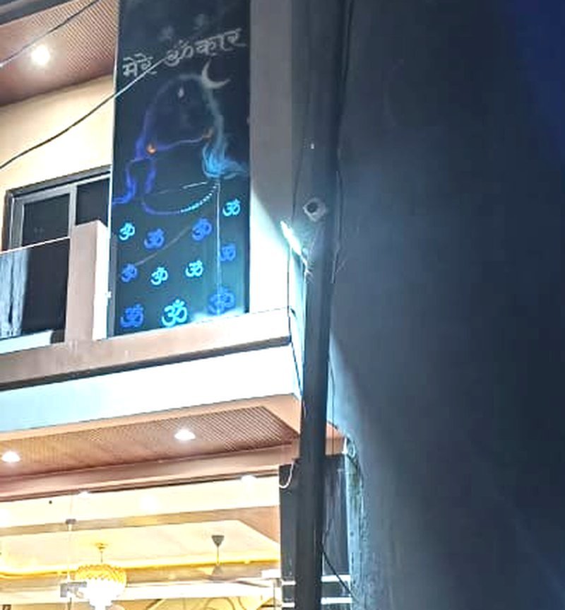 Illuminated panel on Hotel Mahadev Kripa facade reading Mere Omkar